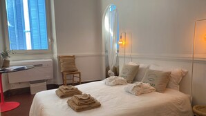 Ein Hotelzimmer mit Bett, Stuhl, Schreibtisch und Spiegel.