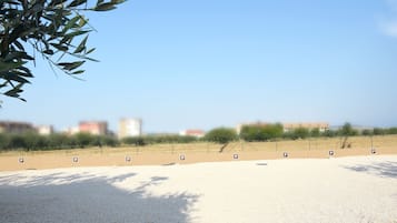 A parking area with multiple parking signs, a gravel surface, and a clear sky.