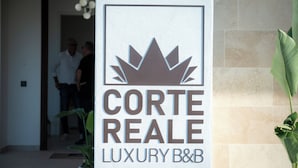 Skilt for Corte Real Luxury B&B med et kronelogo, der angiver et eksklusivt etablissement.