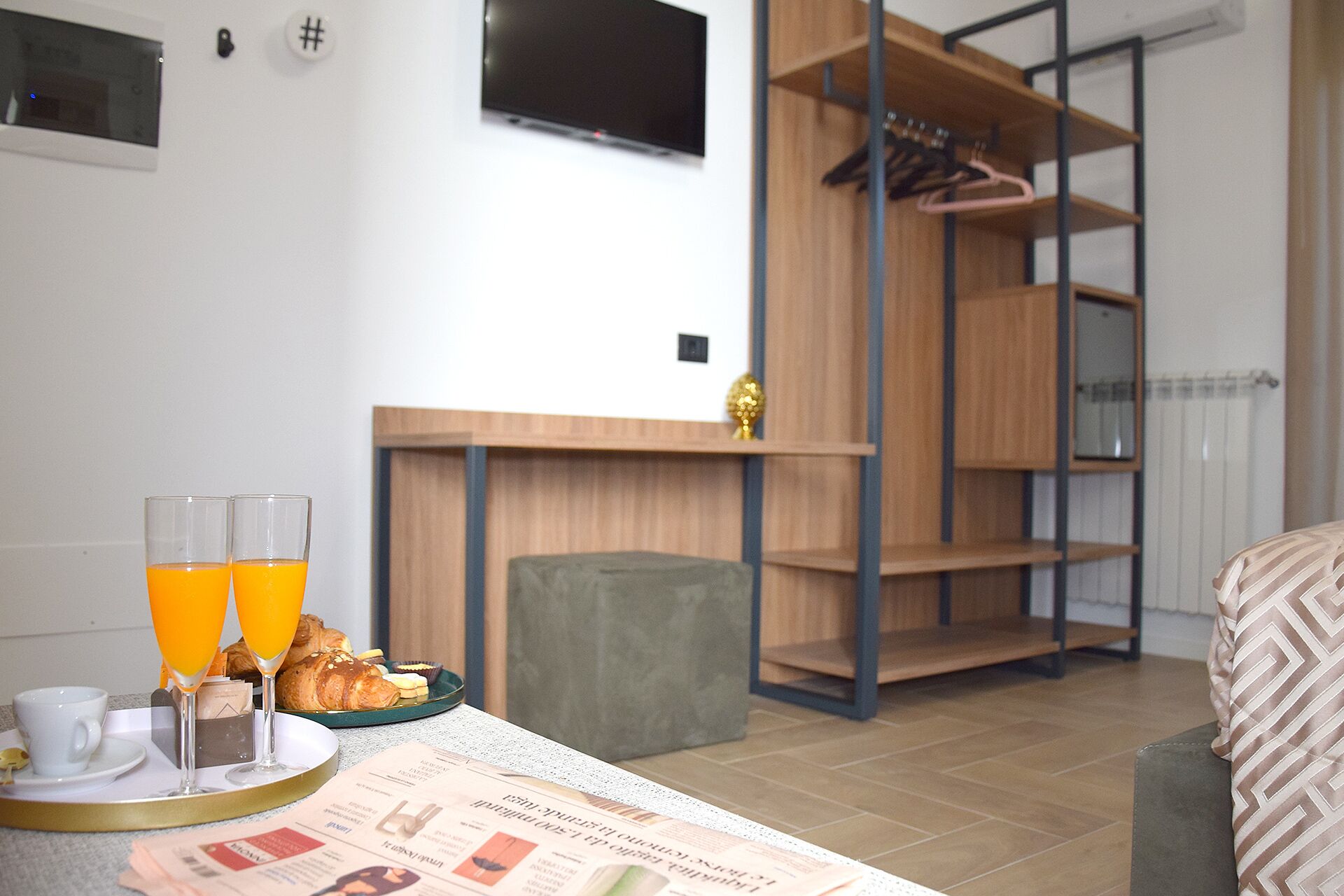 Et moderne værelse med spiseplads, fjernsyn og garderobe.