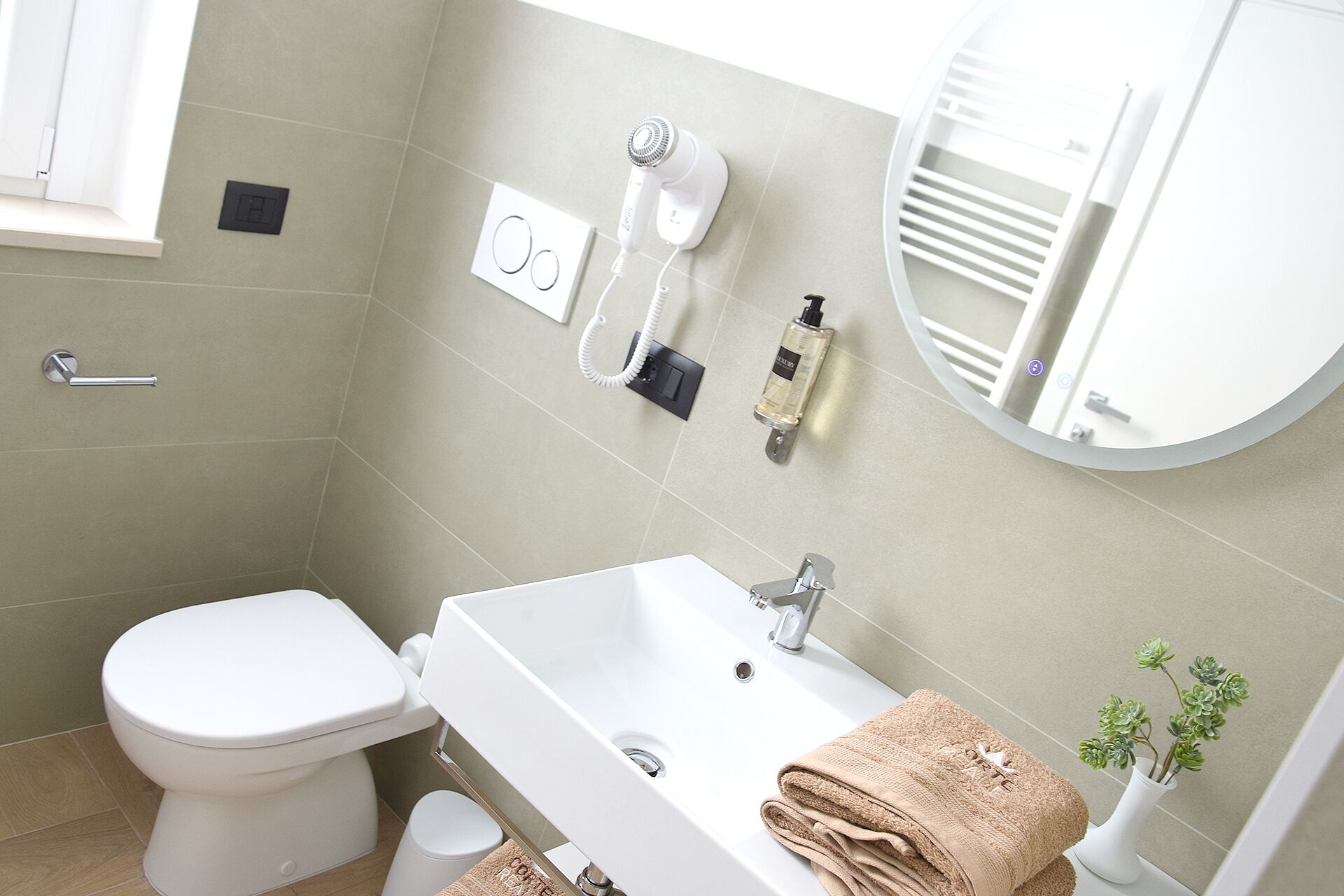Une salle de bain équipée de toilettes, d’un lavabo et d’un porte-serviettes.