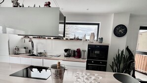 Eine moderne Küche mit einer zentralen Kochinsel, einem Weinglashalter und einer Champagnerflasche.