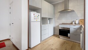 Une cuisine moderne avec des meubles blancs, un four en acier inoxydable et un micro-ondes encastré.