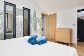 Une chambre à coucher avec un lit, une commode en bois et une armoire.