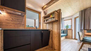 Eine moderne Küche mit Holzschränken, einem Einbauherd und einem großen Fenster.