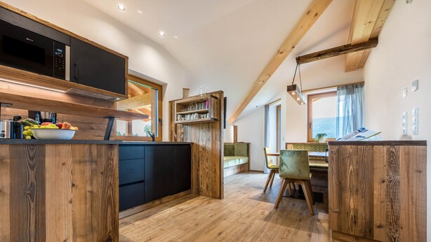 A modern kitchen with wooden cabinetry, a built-in microwave, and a fruit bowl. - Holiday Apartment "Forchnerhof 4" with Mountain View, 2 Private Terraces & Wi-Fi (Terenten)