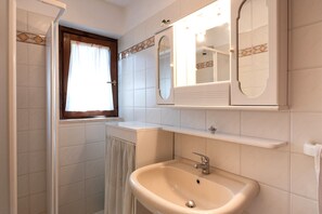 Ein Badezimmer mit Waschbecken, Spiegel und Fenster.