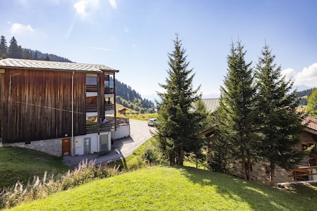 A rustic wooden building with a stone foundation, a balcony, and a view of a mountain range.. Holiday Apartment "Les Saisies" Ski in/ski Out