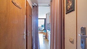 Un pasillo con puertas de madera, un baño con inodoro y lavabo, y un cuadro en la pared.