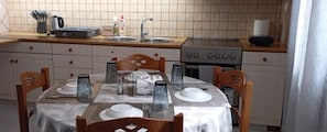Réfrigérateur, un four, surface de cuisson, vaisselle et ustensiles