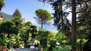 A garden with a stone pathway, statues, and lush greenery.