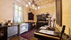 A vintage kitchen with a checkered floor, a large window, and a chandelier.