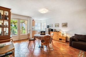 A dining area with a round table, chairs, a cabinet, and a sofa. - Apartment 'Laurin' with Vineyard & Mountain Views (Kaltern)
