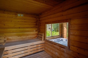 Un sauna en bois, avec des bancs et une fenêtre.
