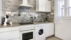 A kitchen with a built-in washing machine, a stove, and a sink. - Apartment "EleMe I" with Private Terrace & Wi-Fi (Vejer)