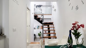 A modern interior with a staircase, dining area, and a small plant. - Apartment "EleMe I" with Private Terrace & Wi-Fi (Vejer)