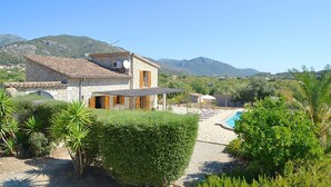 A stone villa with a swimming pool, surrounded by lush greenery and mountains. - Country House 'Sa Volta' with Mountain View, Wi-Fi and Air Conditioning (selva)