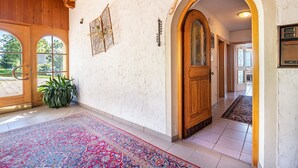 A hallway with a wooden door, a patterned rug, and a potted plant. - Apartment 'Apt Gaisler' with Mountain View, Private Terrace and Wi-Fi (Maranza)