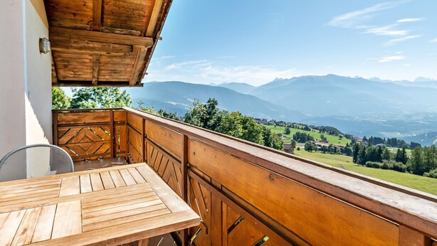 A wooden balcony with a table and chairs, overlooking a mountainous landscape. - Studio Apartment 'Spinges' with Mountain View, Private Terrace and Wi-Fi (Maranza)