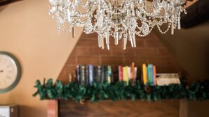 A chandelier, books, and a fireplace mantel. - Holiday Apartment 'Glicine' with Mountain View, Shared Pool & Wi-Fi (Montieri)