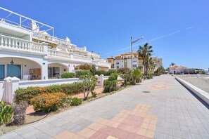 A coastal hotel with a white facade, balconies, and a paved walkway. - 'Frontline Vacation Home A86' Apartment with Sea Views, Shared Pool and Wi-Fi (TORROX COSTA)