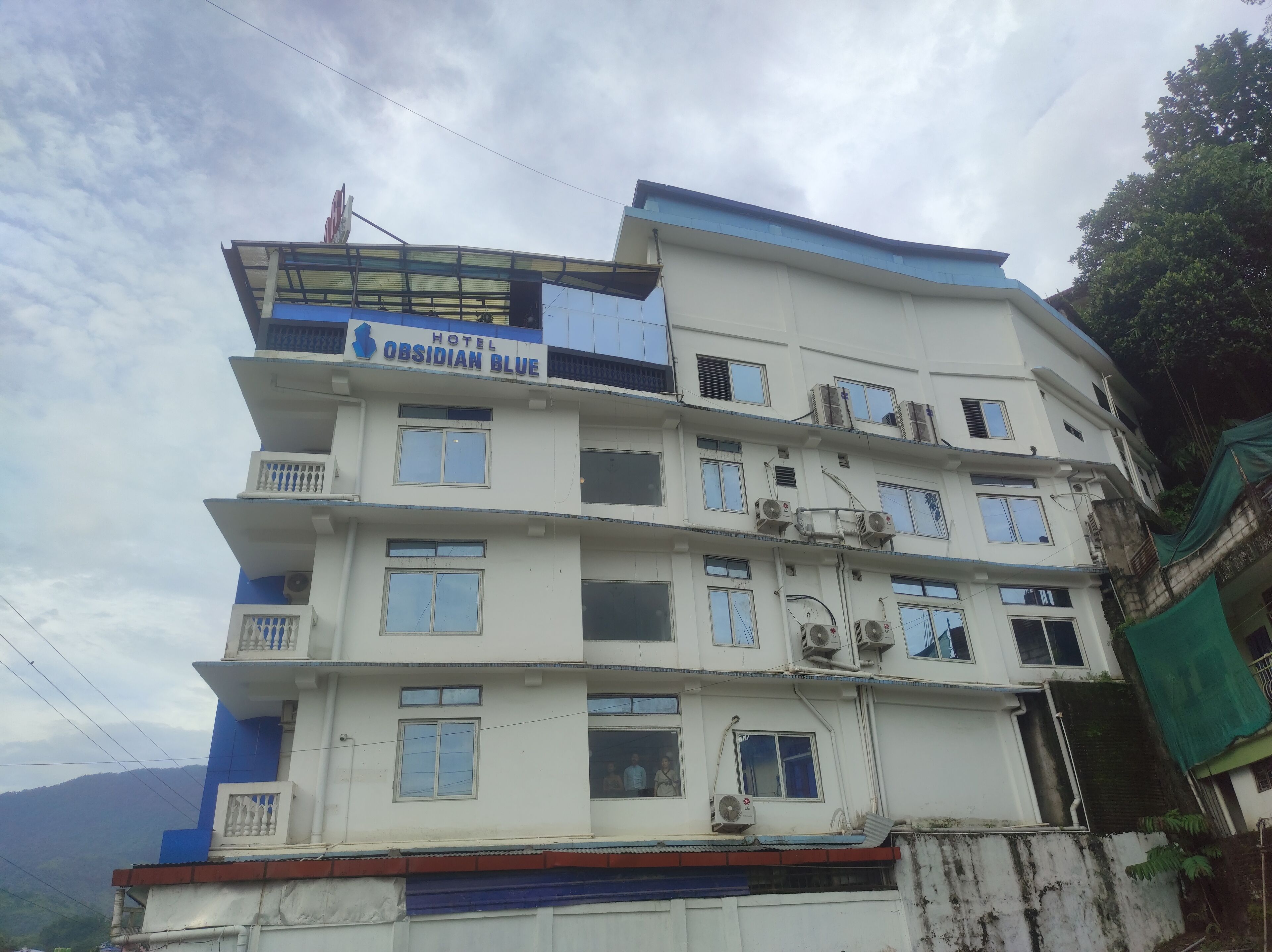 Un hôtel à plusieurs étages, doté de balcons et de climatiseurs.