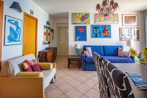 A living room with a sofa, a coffee table, and a blue couch. - Holiday Apartment 'Solkira' close to the Beach with Sea View, Balcony & Wi-Fi (Capo d'Orlando)