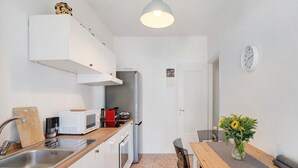 A compact kitchen with a microwave, toaster, and sink. - Holiday Apartment 'Margherita' with Sea View, Balcony & Wi-Fi (Ospedaletti)