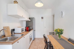 Una cocina compacta con microondas, tostadora y lavabo.