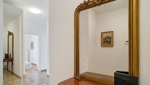 A room with a large mirror, a wooden dresser, and a painting on the wall. - Holiday Apartment 'Margherita' with Sea View, Balcony & Wi-Fi (Ospedaletti)