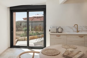 Una cocina moderna con una puerta corrediza de vidrio que da a un patio exterior.
