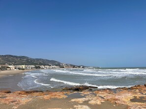 A beach with waves, rocky shore, and buildings in the background. - Country House 'Villa La Vista' with Sea View, Private Pool and Wi-Fi (Alcossebre)