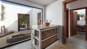 A modern kitchen with a wooden countertop, wicker baskets, and a view of the outside. - Vacation Home "Centenary Canarian Country House" with Sea View, Private Terrace & Wi-Fi (Punta Gorda)