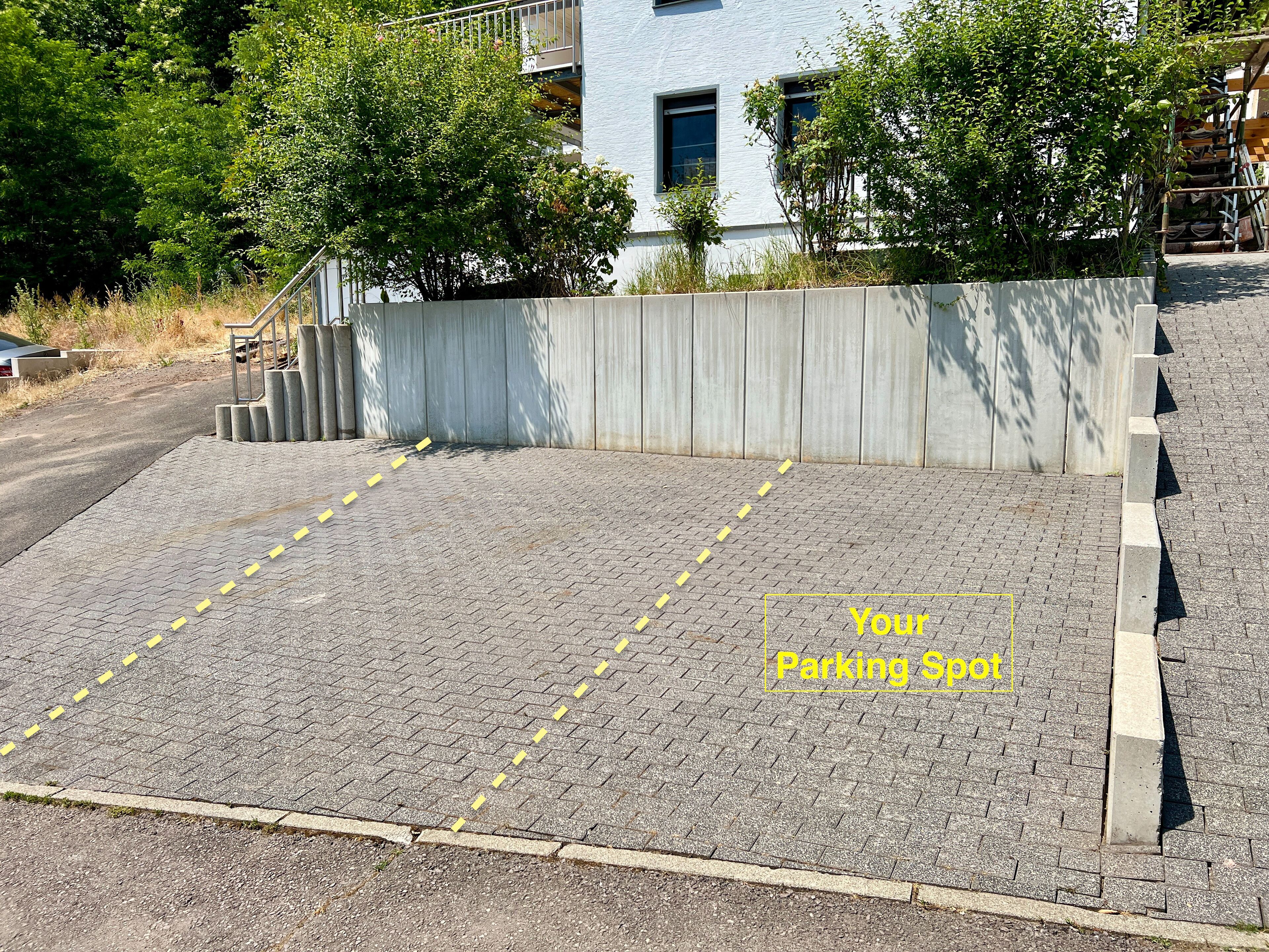 A paved area with yellow dashed lines indicating a parking spot.