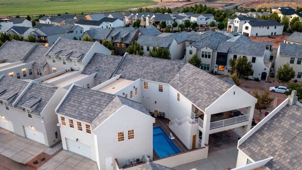 Zona residencial con varias casas de techo a dos aguas y una piscina central.