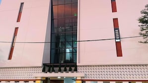 Un hôtel reconnaissable à son grand panneau jaune sur lequel on peut lire « VICTORY HOTEL », placé au-dessus de l’entrée.