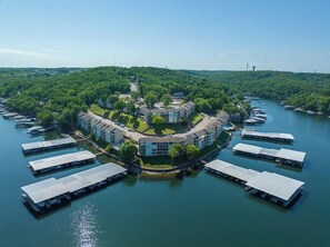 A waterfront property with a central building surrounded by docks and boats. - Lake Life Location with Serenity (Osage Beach)