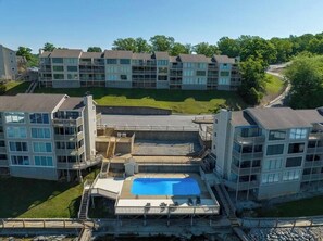 Un immeuble résidentiel à plusieurs étages doté d’une piscine et d’un espace vert.