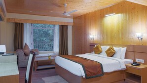 Una habitación con paneles de madera, una cama, un escritorio y una ventana con cortinas.