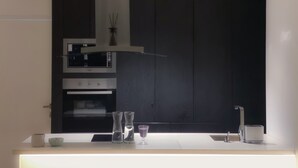 Eine moderne Küche mit Einbauofen, Mikrowelle und Dunstabzugshaube aus Edelstahl.