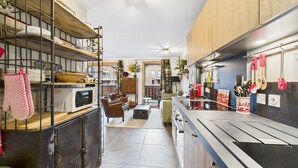 A compact kitchen with a central island, wooden cabinets, and a ceiling fan.