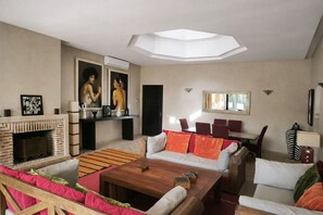 A modern living room with a fireplace, sofas, a coffee table, and artwork on the walls.