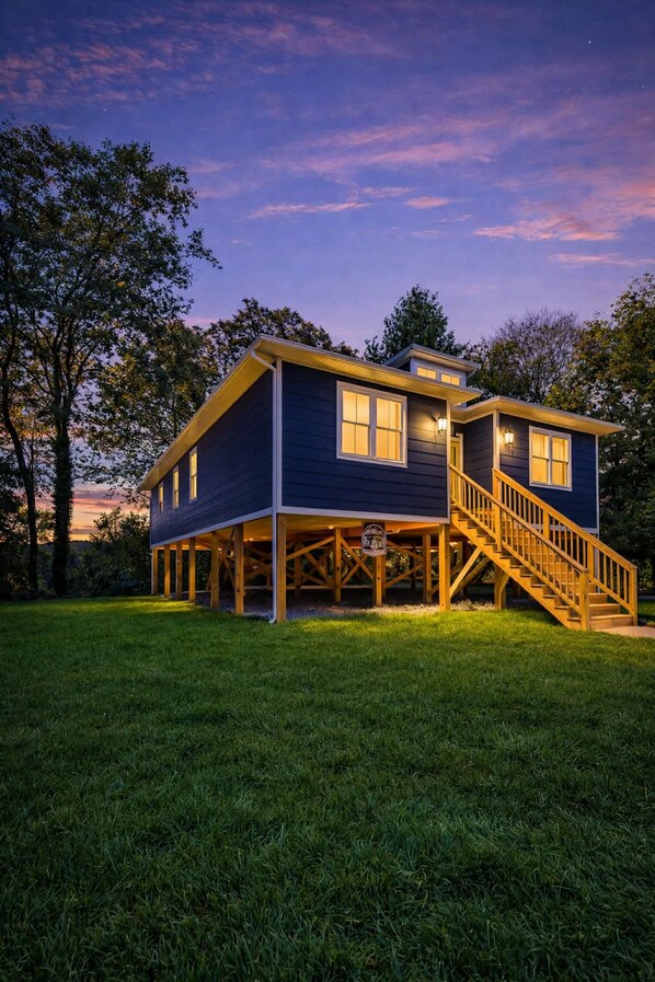 Ein zweistöckiges Haus mit einer Holzterrasse und einer Treppe zum Eingang.