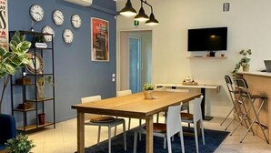 A modern dining area with a wooden table and chairs, a blue carpet, and a wall-mounted TV. -  The Convo Lake Como (Como)