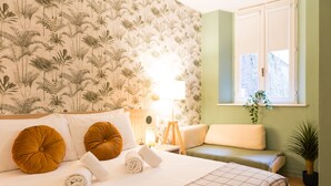 A neatly made bed with two pillows, a bedside lamp, and a window with a plant. -  The Convo Lake Como (Como)