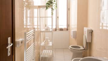 A modern bathroom with a glass shower enclosure, a toilet, and a bathtub.