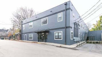 A two-story building with a flat roof, large windows, and a covered entrance.