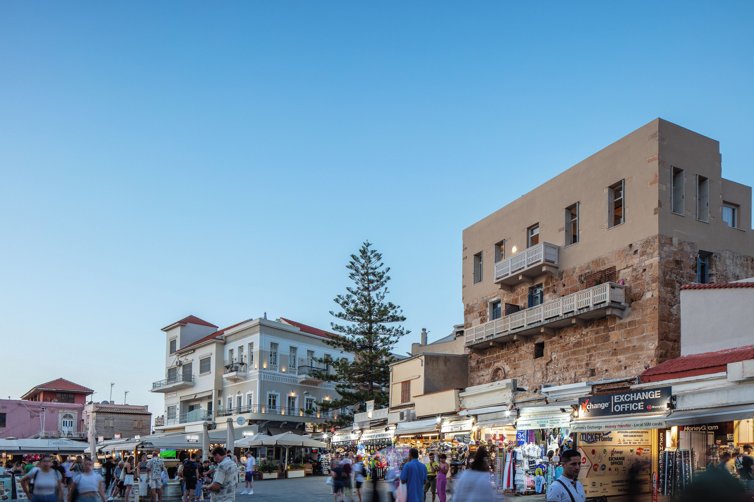A bustling market square with shops and a prominent Exchange Office sign.