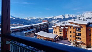 A mountain resort with wooden buildings and a view of snow-covered peaks. - Spacious Apartment 9 pers. · Ski-in/Ski-out · Wifi included (Les Arcs 1800)