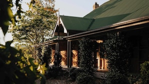 A brick building with a green roof and a covered porch.